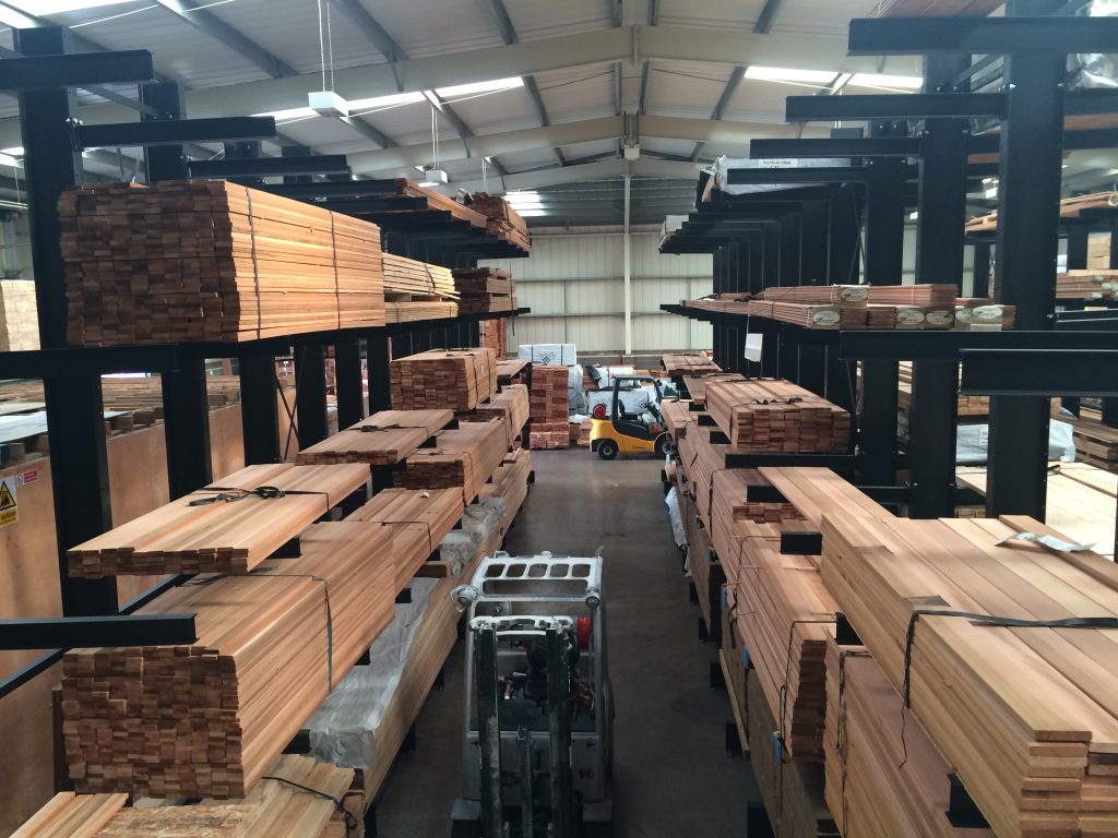 timber warehouse: aisle with racks full of timber packs on both sides