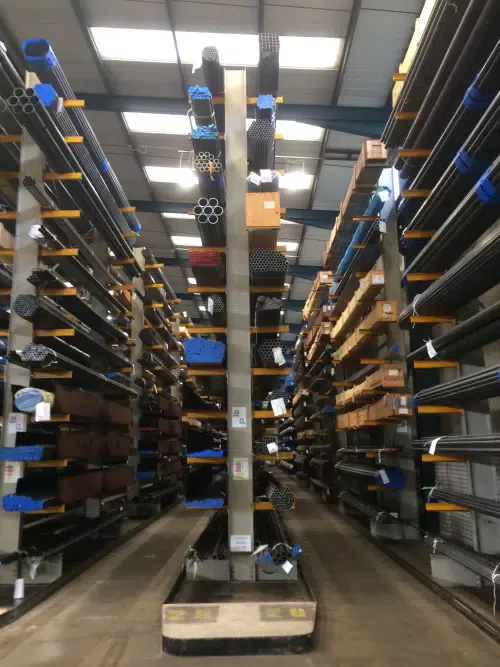 Warehouse with blue cantilever racking storing metal bar and tube on 12 levels in height