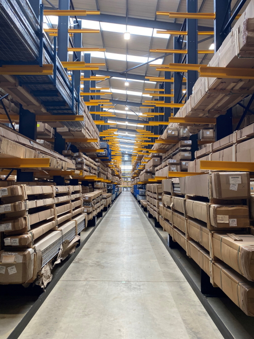 Blue-Cantilever-Racking Cantilever racking with blue uprights and yellow arms storing long, boxed items